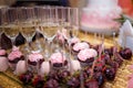 festive candy bar with cupcakes, champagne glasses and strawberries in chocolate glaze. Unfocused pink cake on background. Weddin Royalty Free Stock Photo