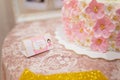 Pink envelope with inscription - Zlata is 1 year old. Lace table cloth and cake with cream flowers with golden beads.