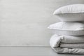 Soft folded blanket and pillows on light grey table, closeup. Space for text Royalty Free Stock Photo