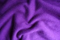 Soft folds on violet knitted fabric