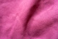 Soft folds on cerise-colored faux suede fabric