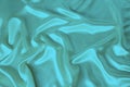 Soft folds on delicate turquoise shining silk, luxury concept, background for the designer, horizontal, close-up, copy space