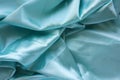 Soft folds and highlights of turquoise silk fabric background. Smooth elegant wavy light blue satin cloth texture. Royalty Free Stock Photo