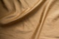Soft folds on simple sandy brown fabric