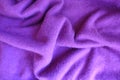 Soft folds on violet knitted fabric