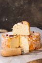 Soft French cheese on wood cutting board, cut off slice, fork, red pepper corns