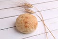 Soft and fresh sesame bun with wheat next to it on a white timber table Royalty Free Stock Photo