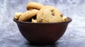 Soft freshly baked cookies with chocolate chips in a brown earthenware plate on gray marble. American traditional sweet pastry