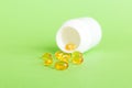 Soft gels pills with Omega-3 oil spilling out of pill bottle close-up. Gel capsules bottle white surface. Omega 3 Royalty Free Stock Photo