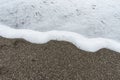 Soft and gentle waves foam in italy stone sand coast shore in summer evening as background Royalty Free Stock Photo