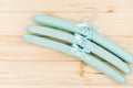 Soft green hangers for clothes on beige wooden background. Empty cloth hanger template. Fashion blog, sales, store,