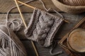 Soft grey woolen yarn, knitting, needles and glass of coffee on wooden table, flat lay Royalty Free Stock Photo