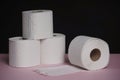 Soft hygienic toilet paper on black pink background.