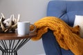 Soft knitted blanket on armchair indoors, closeup. Home interior Royalty Free Stock Photo