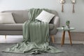 Soft knitted blanket on sofa in room. Home interior Royalty Free Stock Photo