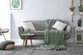 Soft knitted blanket on sofa in room. Home interior Royalty Free Stock Photo