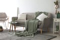 Soft knitted blanket on sofa in room. Home interior Royalty Free Stock Photo