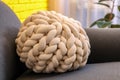 Soft knitted pillow on sofa indoors, closeup Royalty Free Stock Photo