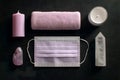 Soft lavender elements arranged on a dark surface, including a face mask, candle, towel, crystal, and gemstone, creating a calming Royalty Free Stock Photo