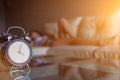 Soft light and Blurred image, alarm clock placed next to bed woke up at set time for woman to wake up and prepare to leave for