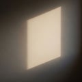 Soft light creates a rectangular shape on a smooth neutral toned wall Royalty Free Stock Photo