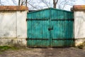 Old, wooden, green gate to the property. Brick, plastered fence. Royalty Free Stock Photo