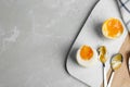 Soft and medium boiled chicken eggs on grey marble table, flat lay. Space for text