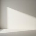 Soft, natural light casts a triangular shadow on a smooth, light-colored wall. The shad Royalty Free Stock Photo