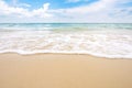 Soft ocean wave on sandy beach with blue sky