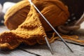 Soft orange knitting, yarn and metal needles on wooden table, closeup Royalty Free Stock Photo