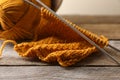 Soft orange knitting, yarn and metal needles on wooden table, closeup Royalty Free Stock Photo