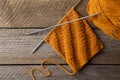 Soft orange yarn, knitting and metal needles on wooden table, flat lay Royalty Free Stock Photo