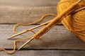 Soft orange yarn, knitting and needles on wooden table, closeup Royalty Free Stock Photo