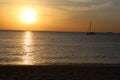 Soft panorama seascape shot of a lonely yacht silhouette in calm ocean at a beautiful yellow orange sunset on a cloudy sky with a Royalty Free Stock Photo