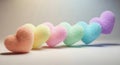 Soft pastel candy hearts arranged in a rainbow gradient on a subtle textured surface Royalty Free Stock Photo