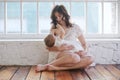 Soft photo young mother feeding breast her baby at home in white room Royalty Free Stock Photo