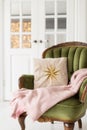 Soft pillow with star symbol and pink plaid lay on green armchair. Selective focus Royalty Free Stock Photo