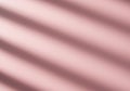 Soft pink background with diagonal shadow lines, resembling window blinds. The Royalty Free Stock Photo