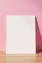 Soft pink background with a simple empty Notepad on a wooden desk, empty, serene