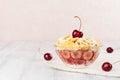 Soft pink breakfast with golden corn flakes, ripe cherries, powdered sugar on white wood board with copy space. Royalty Free Stock Photo