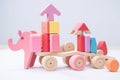 Soft pink and colorful round wooden construction blocks, shapes, elephant for building a children\'s toy for playing.