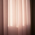 Soft pink curtains, backlit by soft light, create a serene glow. The fabric appears light Royalty Free Stock Photo