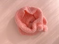 Soft pink lace knitted round scarf isolated on pastel pink background. Fashion children\'s accessory