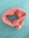 Soft pink lace knitted round scarf isolated on pastel green background. Fashion children\'s accessory