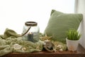 Soft plaid, pillow, burning candle and seashells on windowsill Royalty Free Stock Photo