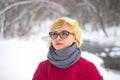 Soft portrait of odd lonely girl sitting in winter snowy forest. Friendless female person with sad emotional