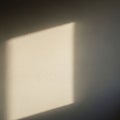 A soft rectangular patch of light casts a shadow on a beige wall Royalty Free Stock Photo