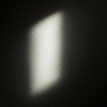 A soft, rectangular patch of light illuminates part of a textured, dark surface, creating Royalty Free Stock Photo