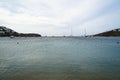 Soft scenic beautiful seascape with sailing boats, yachts, clear sky, mountain and white building background, Ornos beach Royalty Free Stock Photo