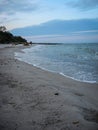 The soft sea waves gently roll on the sandy beach. Beautiful picture of dawn on the seashore Royalty Free Stock Photo